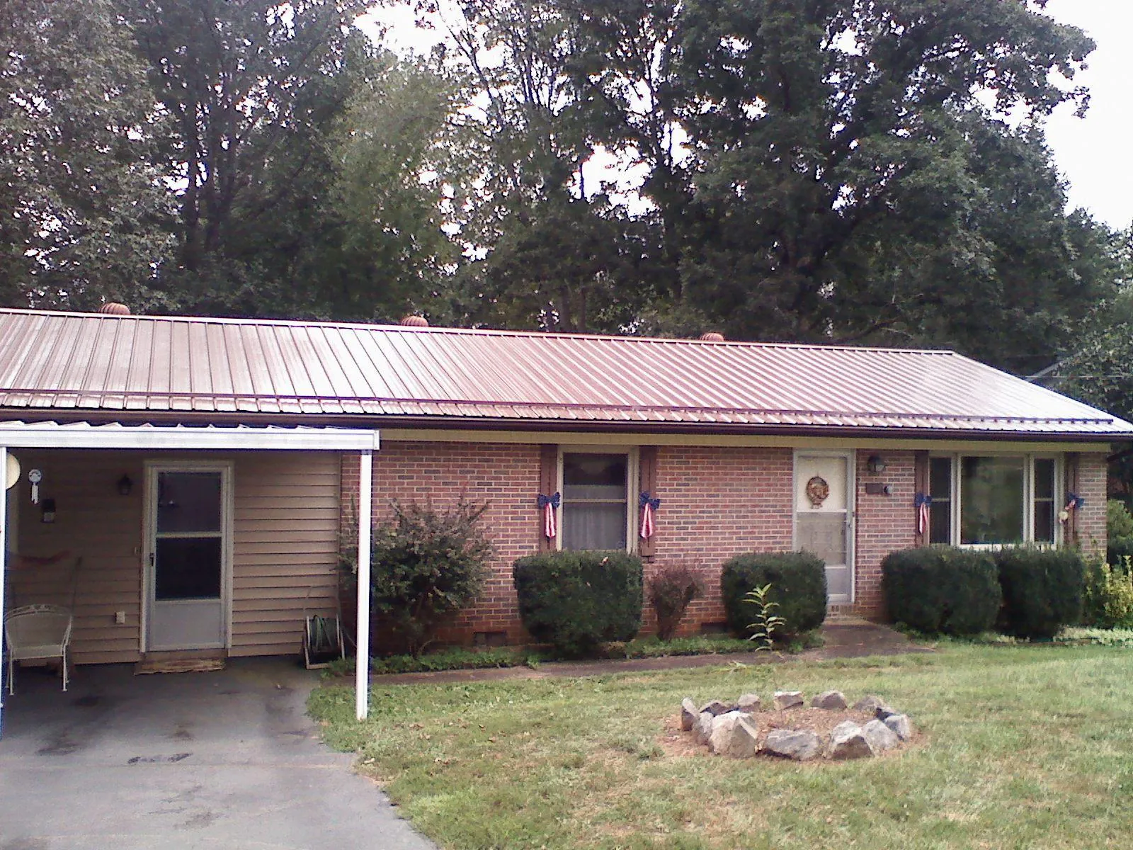 Bronze metal roof and carport on a brick ranch home — Roof Repair work by our crew in Highland